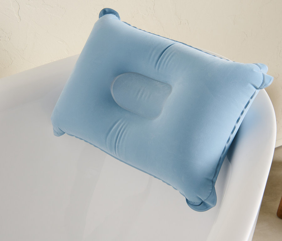 Coussin de baignoire bleu sur une baignoire blanche.