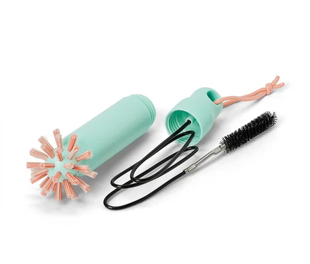 Un ensemble de brosses de vidange 2 en 1 démonté : un boîtier bleu clair, une brosse avec des poils orange et une brosse métallique noire.