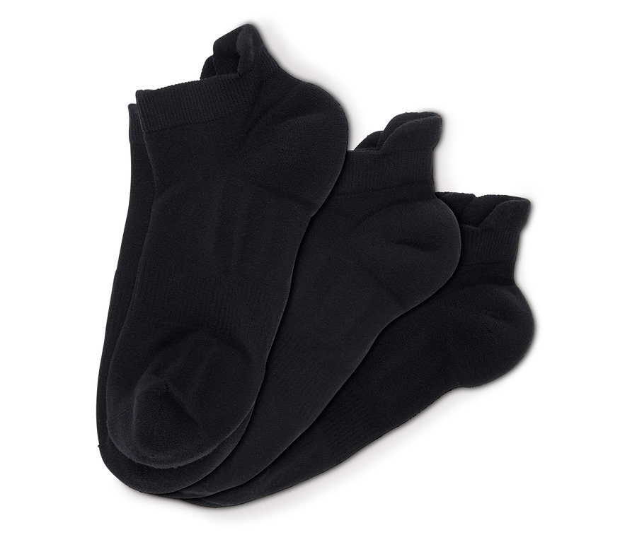 Trois paires de chaussettes noires sur fond blanc.