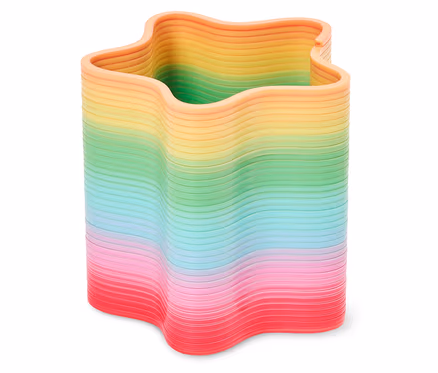 Un pot à crayons en forme d'étoile aux couleurs de l'arc-en-ciel repose sur une surface blanche.