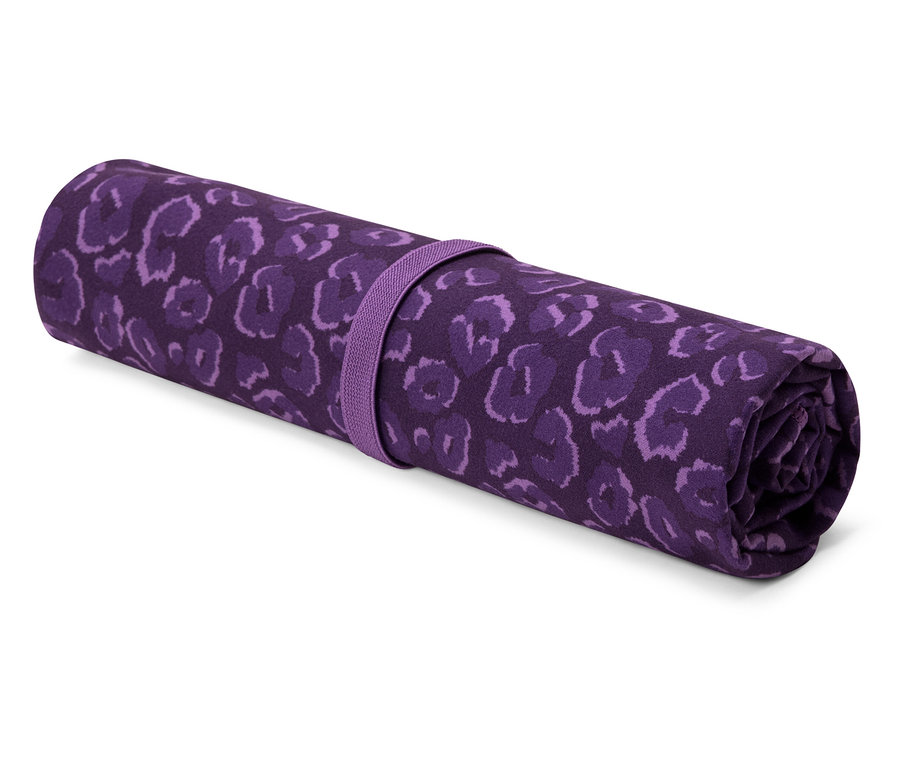 Un tapis de yoga violet enroulé avec un imprimé animalier, sécurisé par une sangle violette.