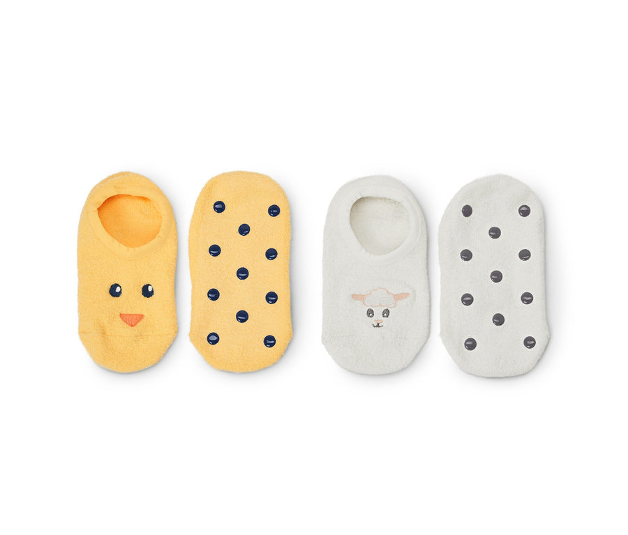 Deux paires de chaussons à enfiler : jaunes avec un visage et des points, blancs avec un mouton et des points.