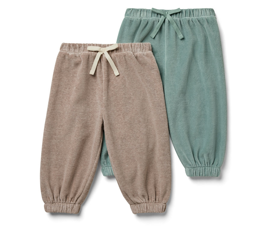 Deux pantalons de survêtement pour enfants : un beige et un vert.