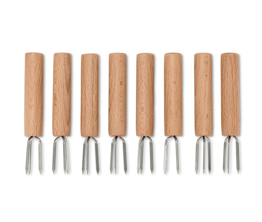 Huit piques à maïs avec des manches en bois et des pointes argentées disposées en rangée.