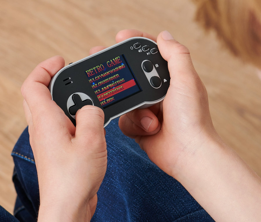 Une personne tient une mini-console de jeux rétro.