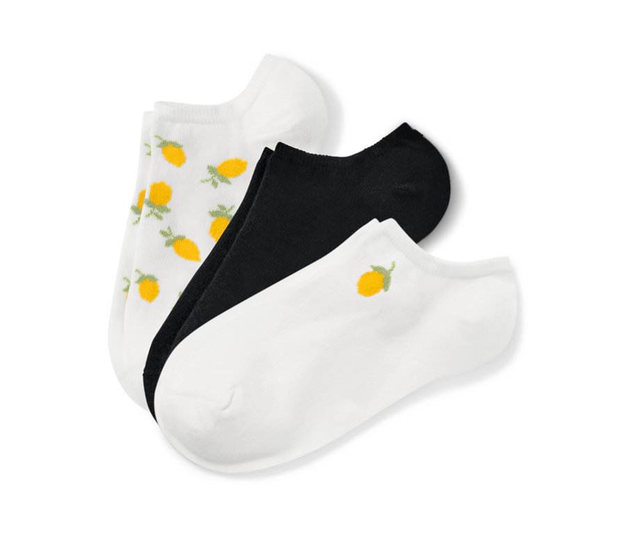 Trois paires de socquettes de sport : une paire blanche à motif citron, une paire noire et une paire blanche avec une broderie citron.