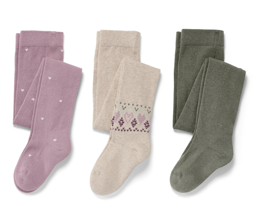 Trois paires de collants pour enfant, une violette avec des cœurs blancs, une beige avec des motifs violets et une vert olive.