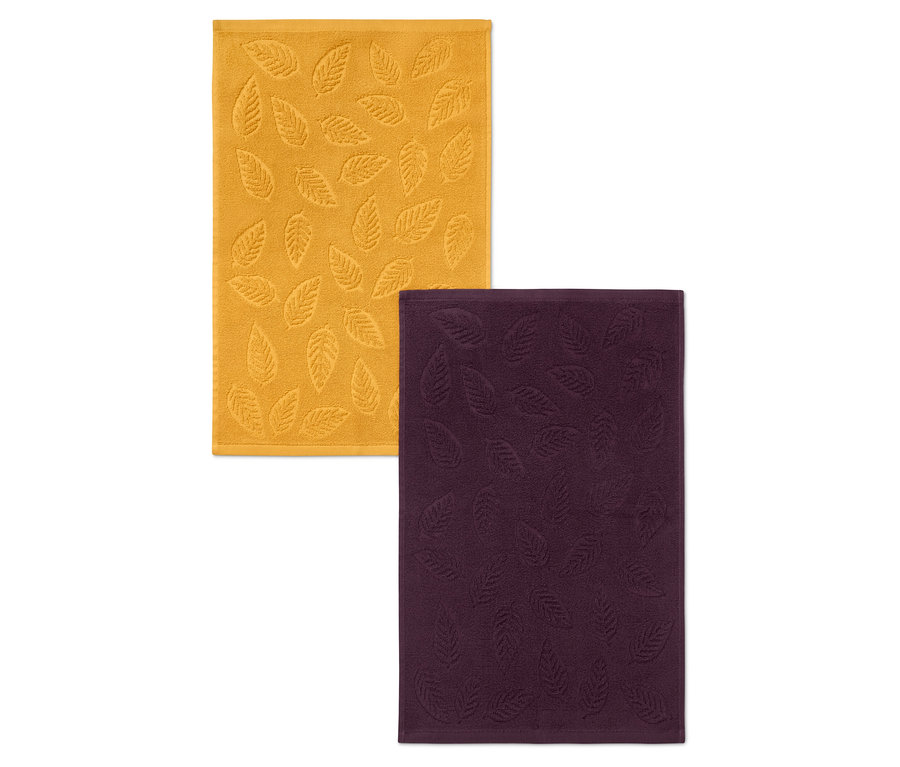 Deux serviettes avec relief de feuilles : une jaune et une violette.