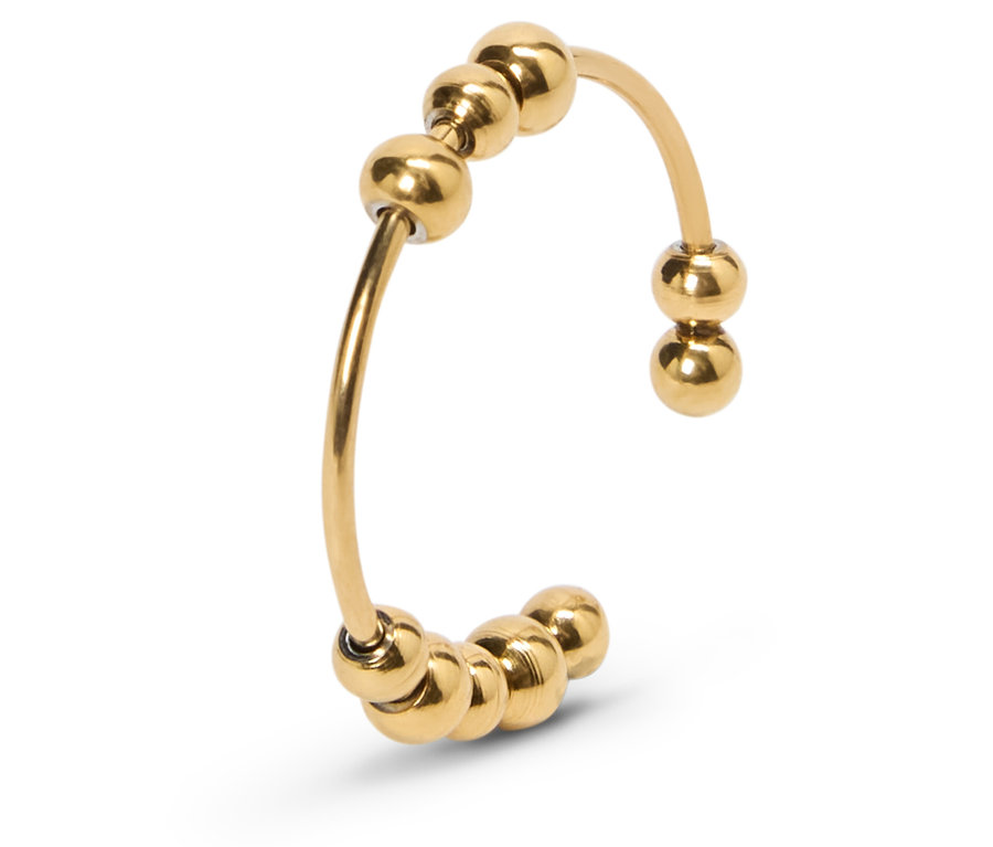 Gros plan d'une bague ajustable dorée avec des perles.