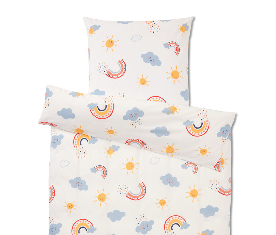 Ensemble de literie avec un motif répété d'arcs-en-ciel, de nuages et de soleils sur fond blanc.