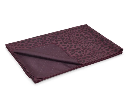 Serviette bordeaux à motif léopard noir, pliée sur un fond blanc.