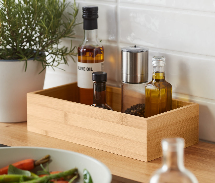 Herbes en pot et deux boîtes à condiments à côté d'une poêle avec des légumes.