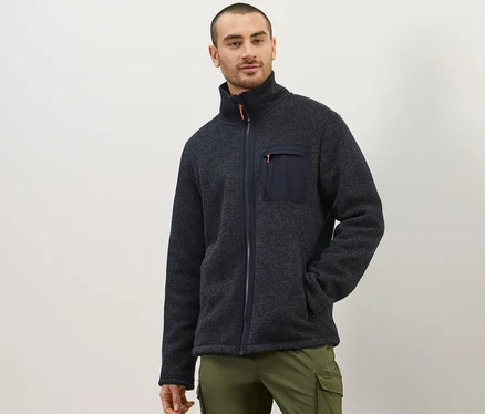 Homme posant en jaquette en polaire tricotée thermique et pantalon olive.