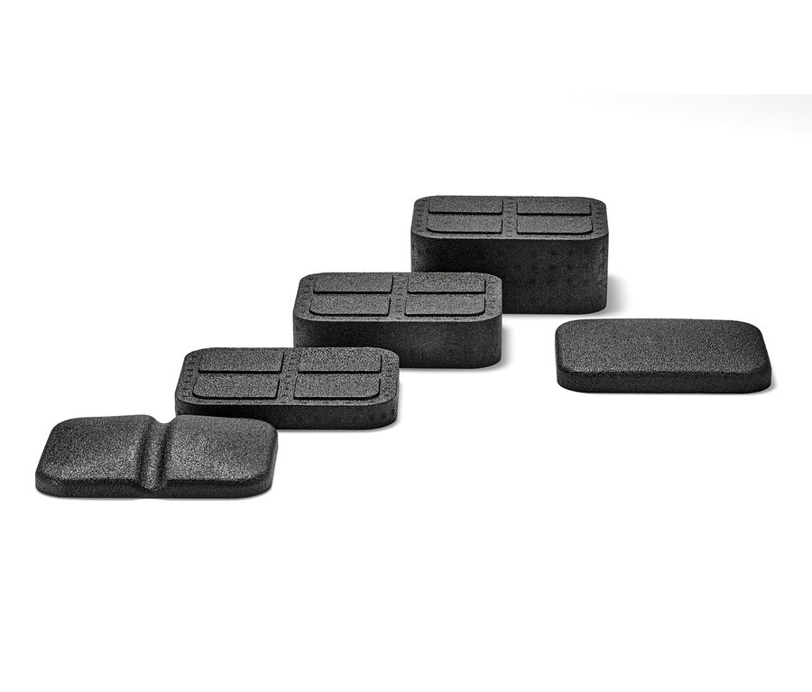 Quatre dispositifs noirs de détente du dos sur fond blanc.