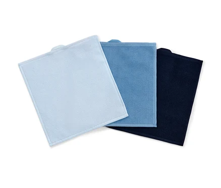 Trois serviettes cosmétiques en microfibre bleues, bleu clair et bleu foncé sont posées les unes sur les autres.