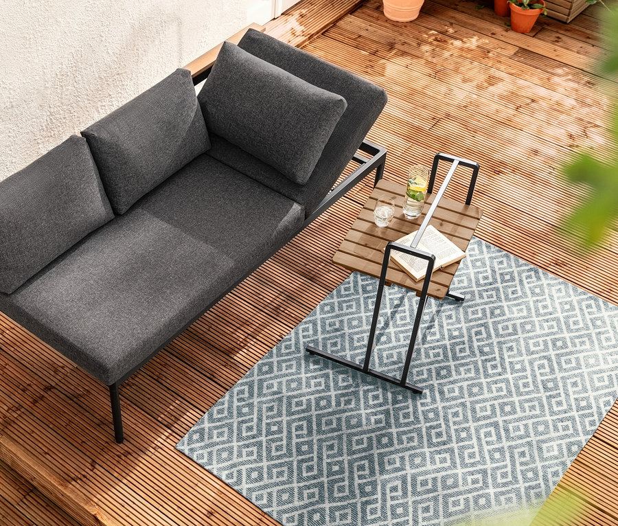 Vue de dessus de la banquette dining 2 en 1 « Elin » à côté de la table en C avec grand plateau sur terrasse en bois.