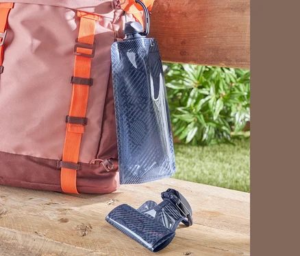 Un sac à dos rose et marron avec des bretelles orange et deux gourdes.