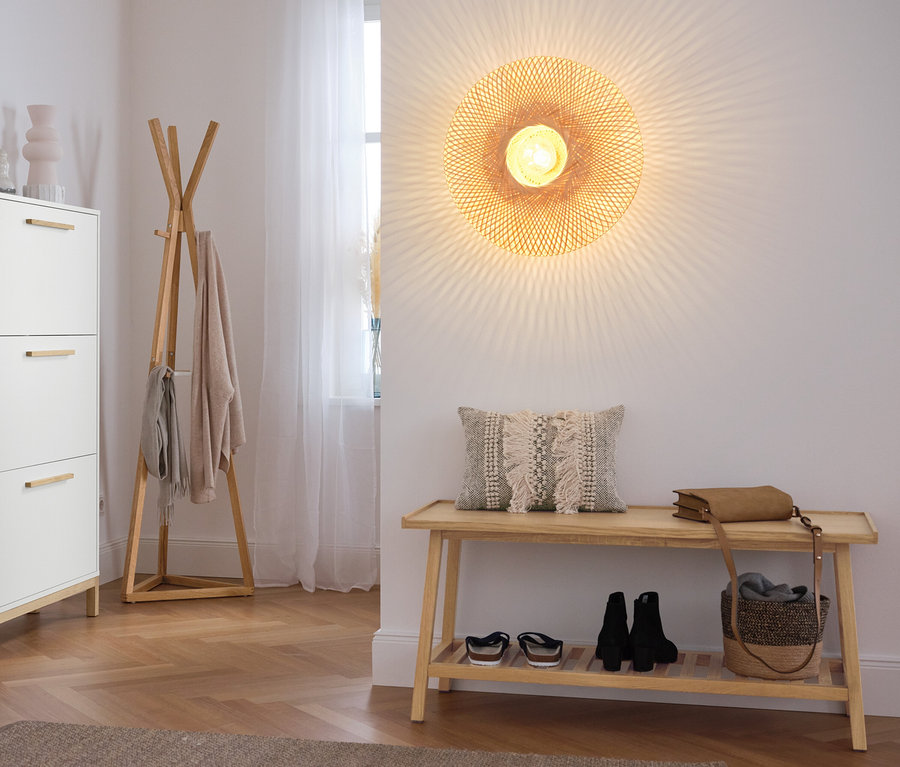Hall d'entrée avec meuble à chaussures, porte-manteau et banc avec étagère.
