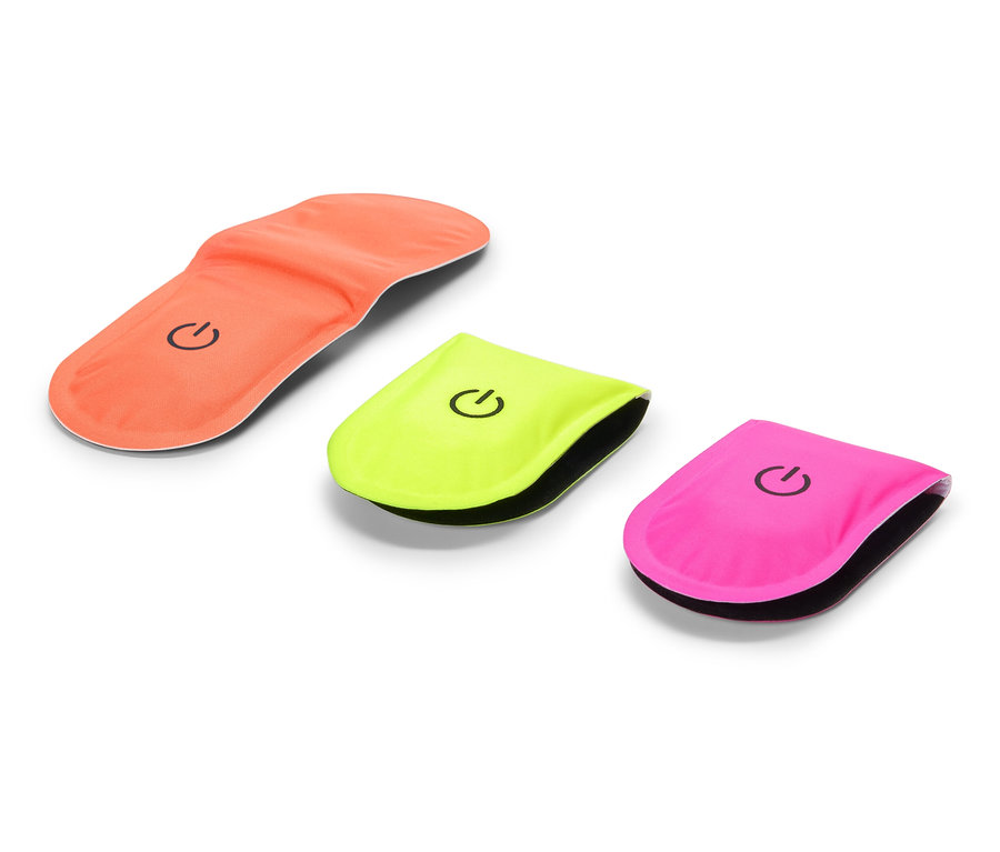 Une semelle intérieure orange est à côté d'une lumière clignotante jaune et rose.
