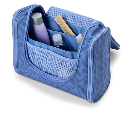 Trousse de toilette ouverte bleu clair contenant divers articles de voyage tels que du shampoing, un peigne et une brosse à dents.