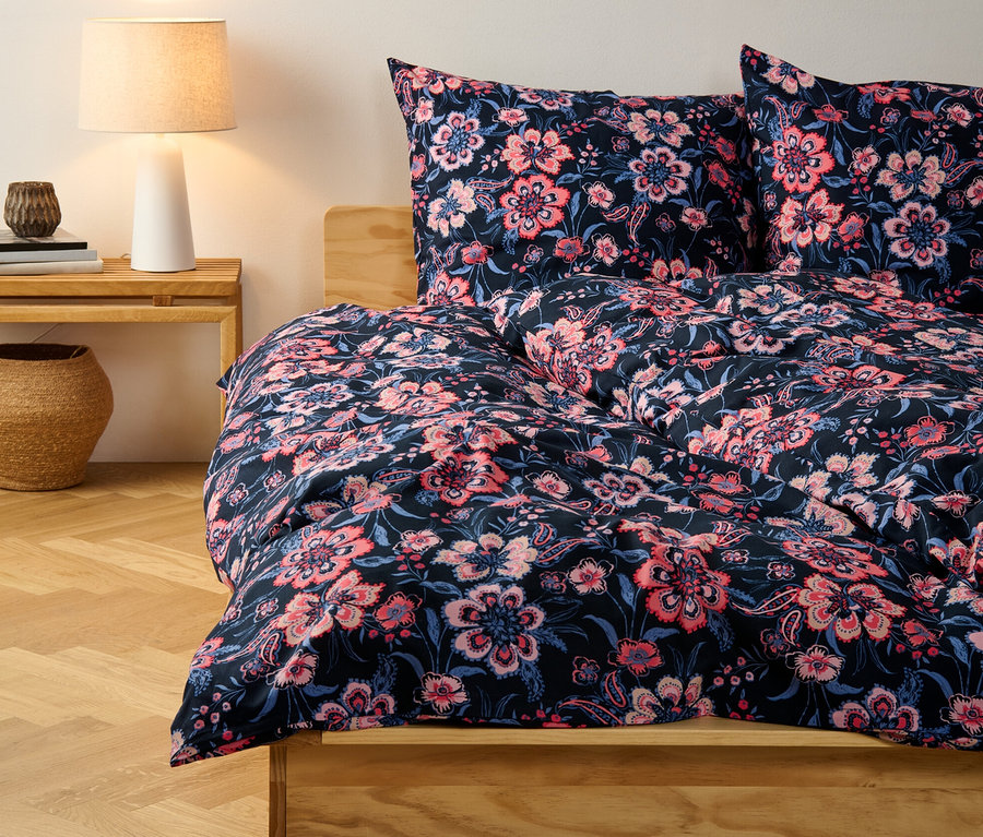 Parure de lit en renforcé bleu foncé à fleurs, taille normale, sur un lit.