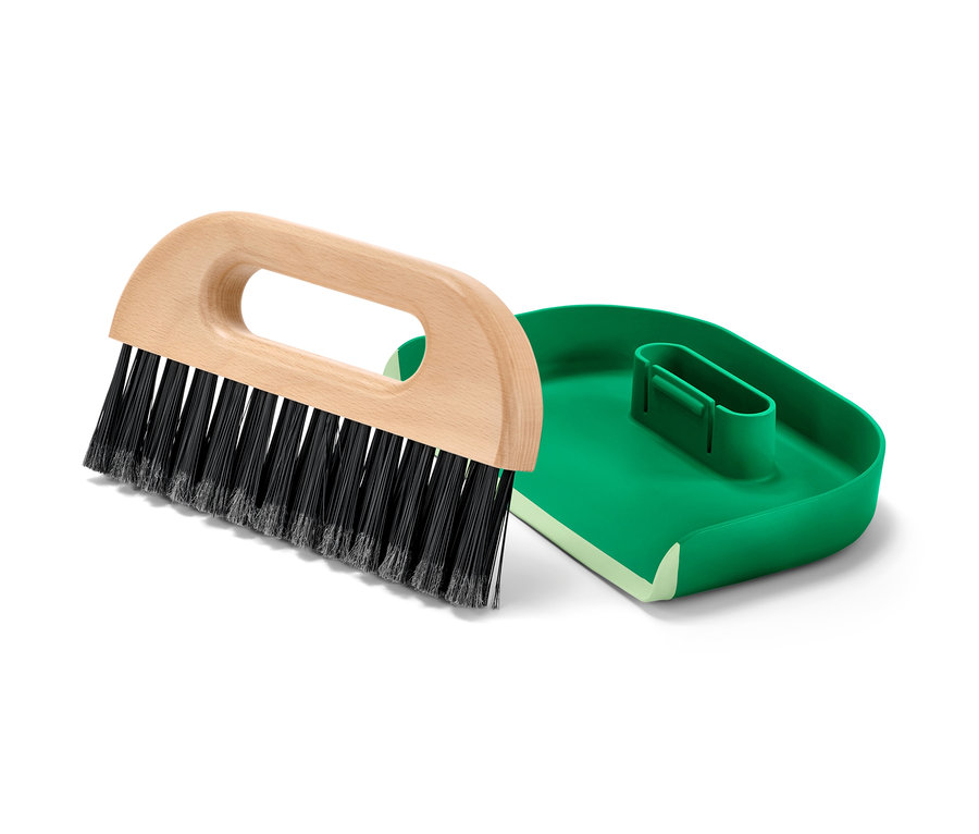 Pelle et balayette sur fond blanc.