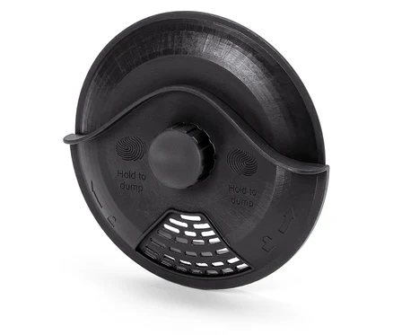 Vue détaillée d'un couvercle en plastique noir avec l'inscription "Hold to dump" et une grille.