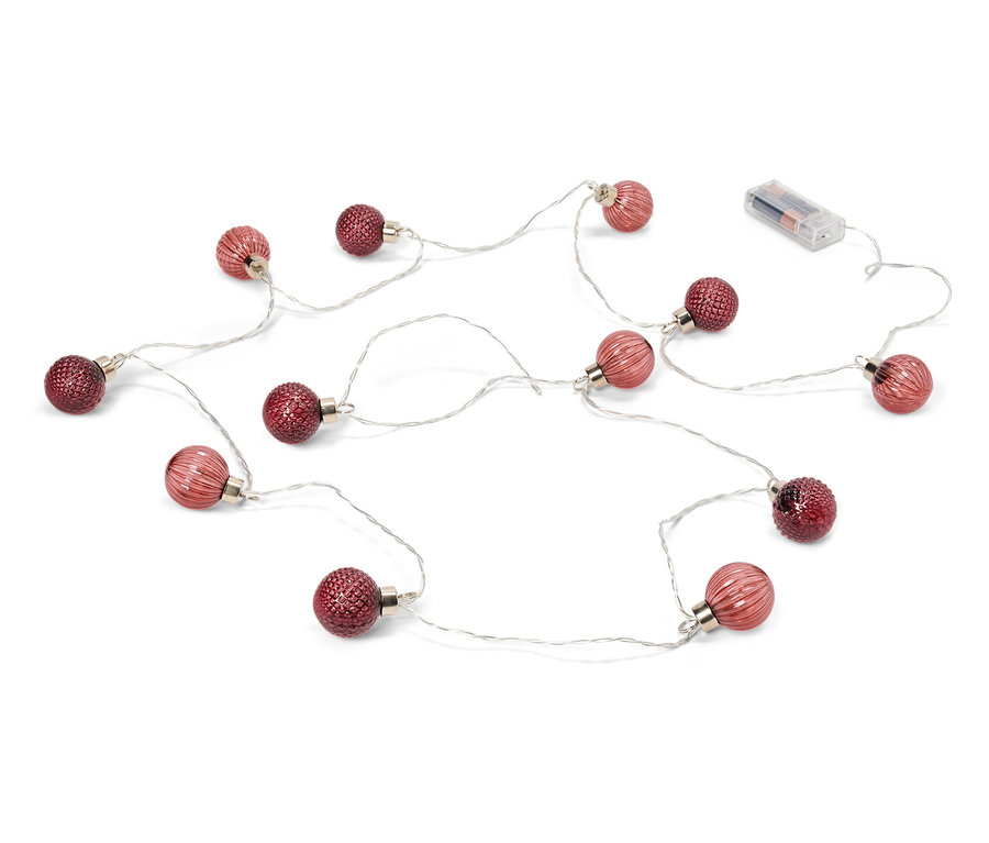 Une guirlande lumineuse avec des boules rouges et des piles sur un fond blanc.