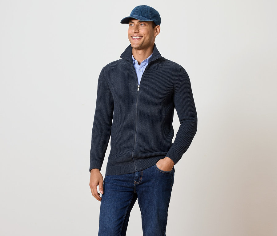 Un homme porte une veste en maille bleu marine chiné.