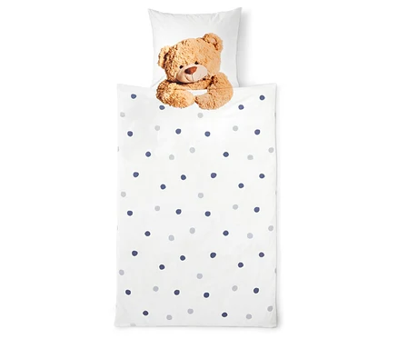 Literie avec un ours en peluche et des points.