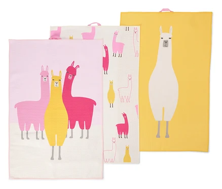 Trois torchons sont superposés. Les torchons sont roses, jaunes et blancs et sont imprimés de lamas.
