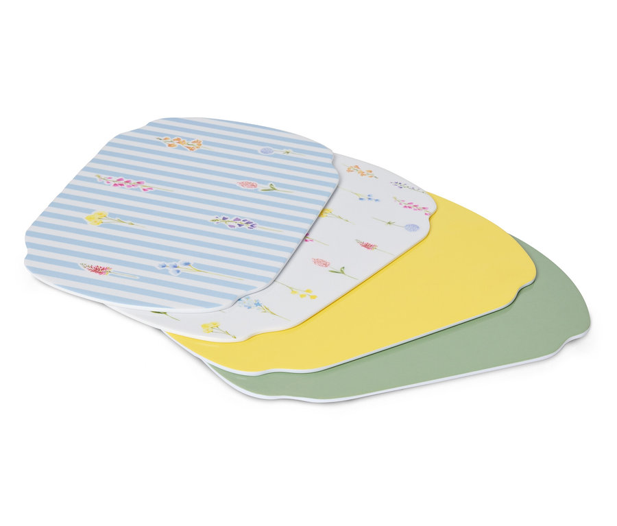 Plusieurs sets de table sont superposés, dont un bleu et blanc rayé, un blanc à motifs floraux, un jaune et un vert.