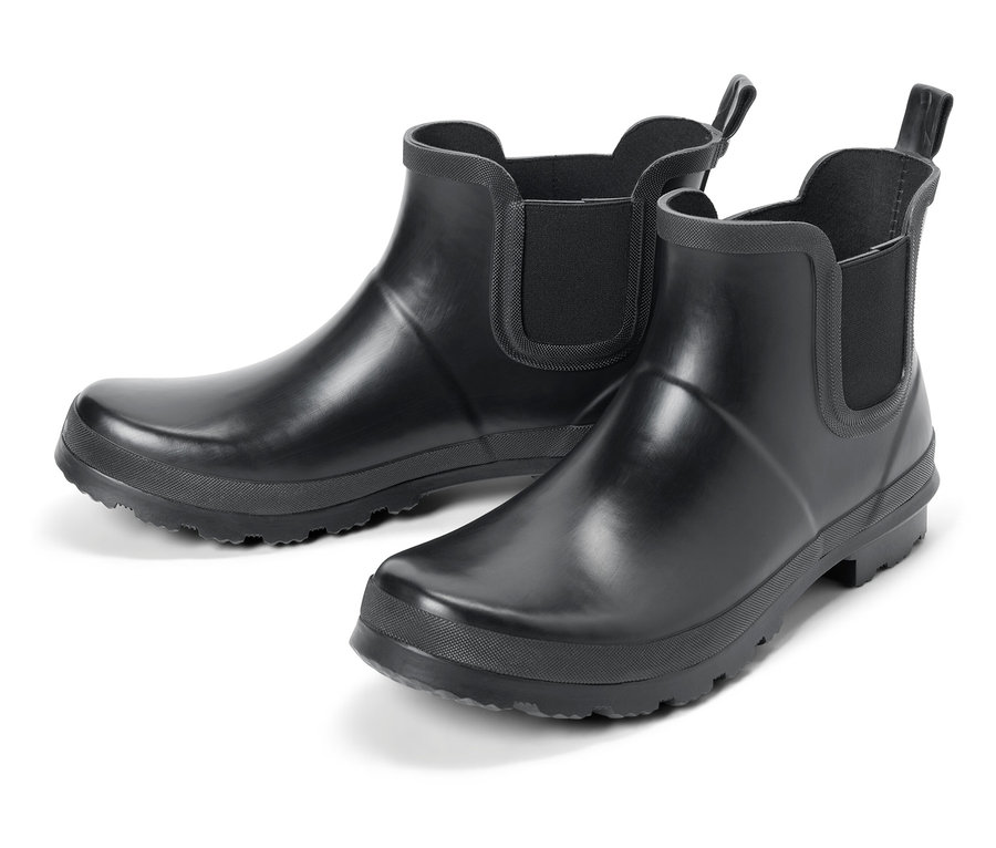 Deux bottes en caoutchouc noires sur fond blanc.