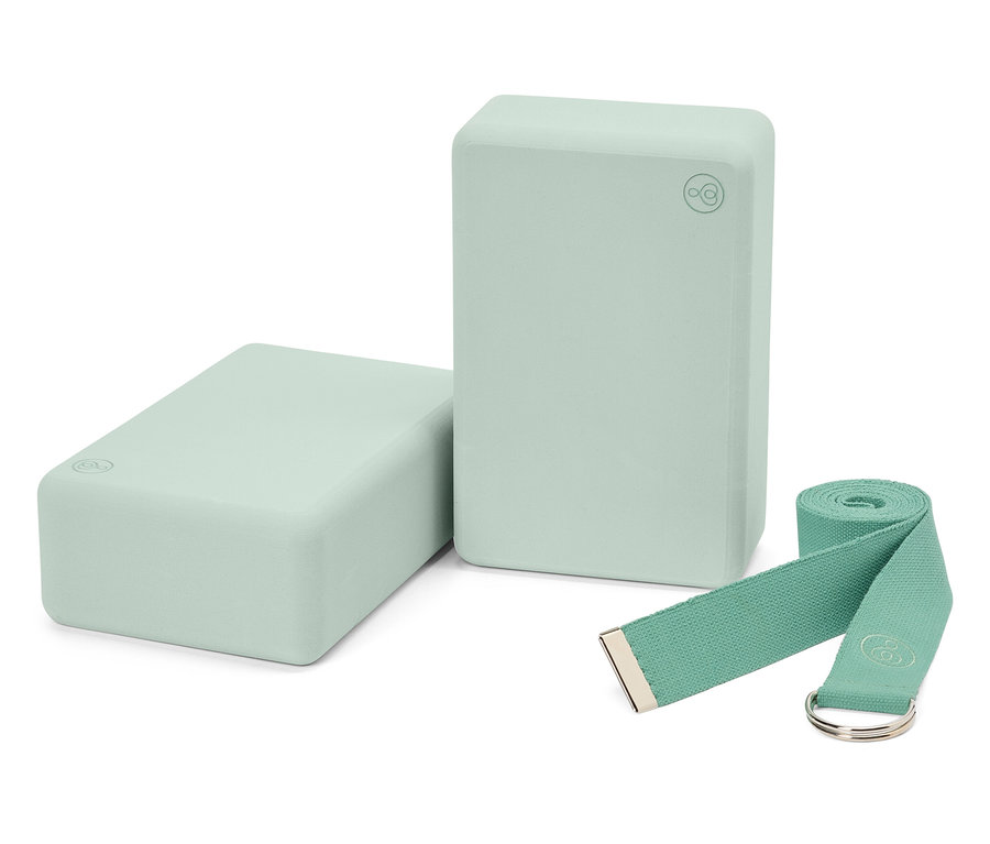 Deux blocs de yoga vert clair et une sangle assortie.