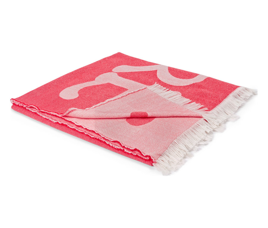 Couverture rouge pliée avec motif blanc et franges aux extrémités.