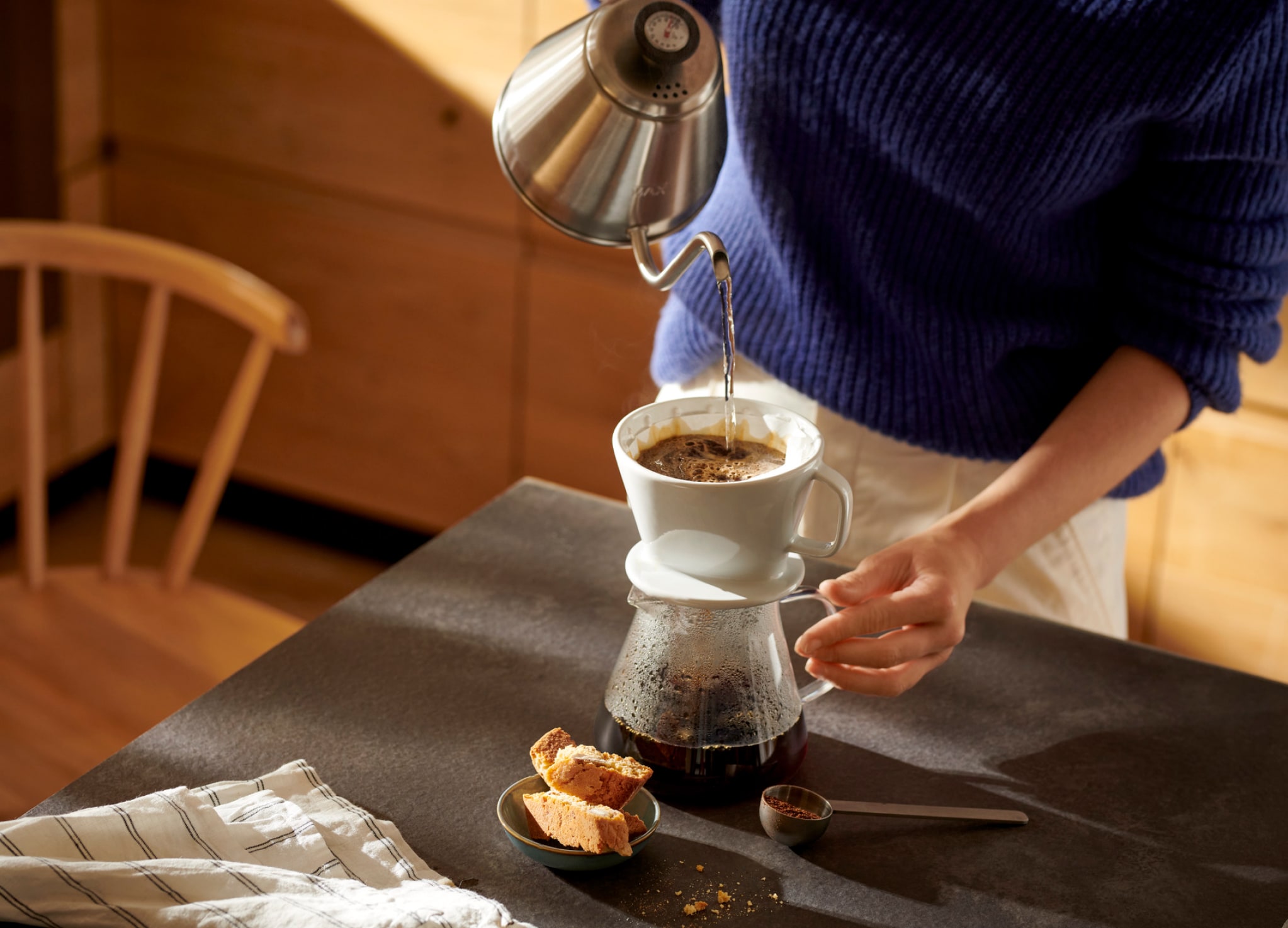 L'homme verse un café fraîchement infusé dans une tasse de verre à